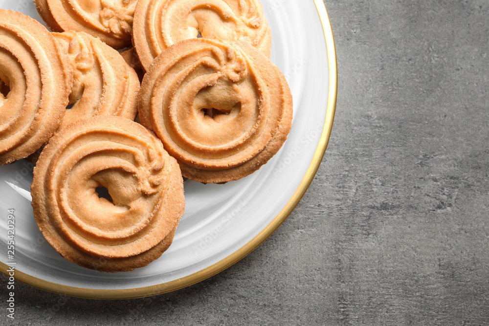 Plate with Danish butter cookies on grey background, top view. Space for text Plate with Danish butter cookies on grey background, top view. Space for text