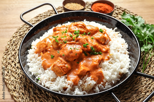 Fotografía Delicious butter chicken with rice in dish on wooden table