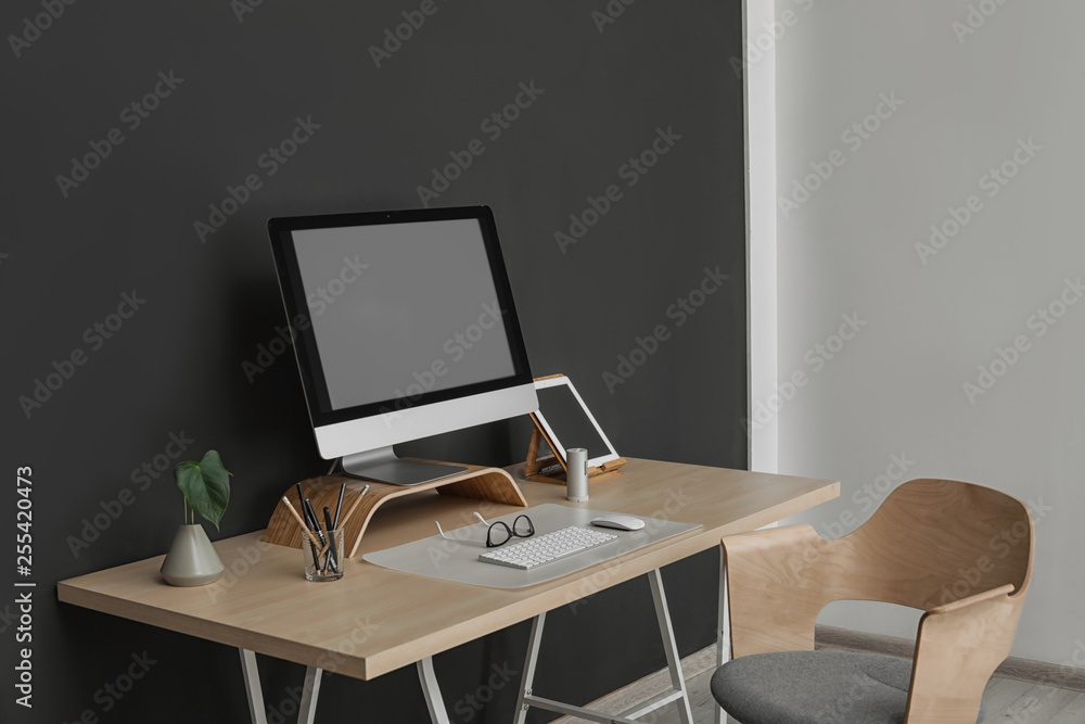 Fototapeta premium Modern workplace interior with computer on table. Space for text
