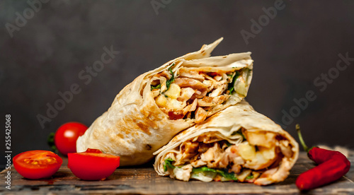 Burrito wraps with chicken and vegetables on a cutting board, against a background of concrete, Mexican shawarma photo
