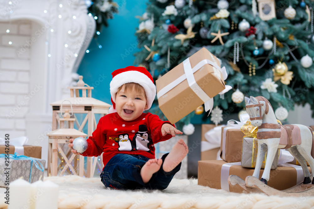 little baby santa claus in christmas hat. Happy new year and merry christmas. Holidays and gifts for children little baby santa claus in christmas hat. Happy new year and merry christmas. Holidays and gifts for children