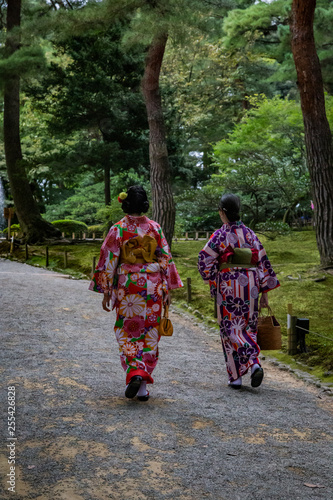 two Japanese women walk through park