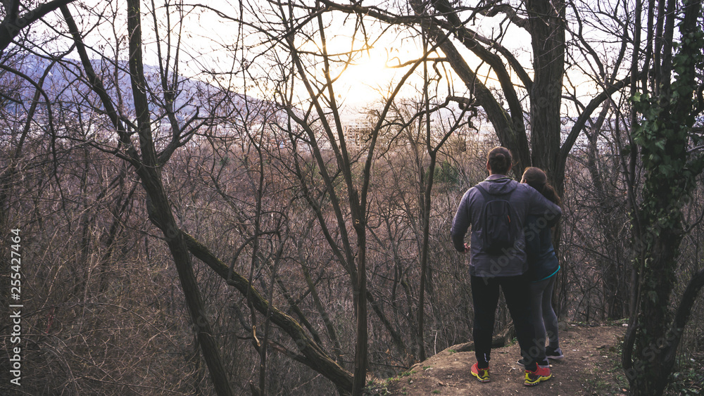 couple hugging looking the sunset in a park of Sofia Bulgaria, enjoying the sun in winter