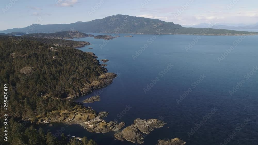Aerial shot high above coastal islands in Canada. Epic view, forest covered islands with rocks and deep blue water. Aerial shot high above coastal islands in Canada. Epic view, forest covered islands with rocks and deep blue water.