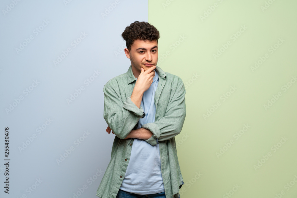 Fototapeta premium Young man over blue and green background looking to the front