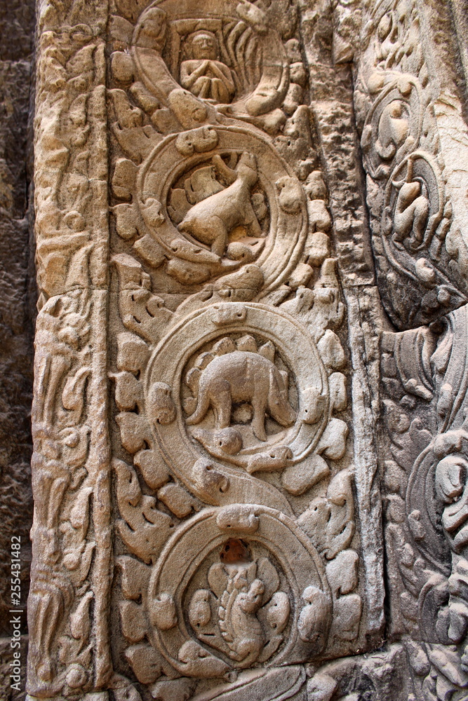 Stone carved bas-relief with a stegosaurus on the wall inside the temple Ta Prohm in Angkor, Cambodia