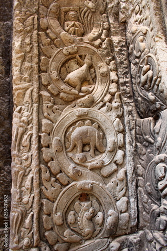 Stone carved bas-relief with a stegosaurus on the wall inside the temple Ta Prohm in Angkor, Cambodia