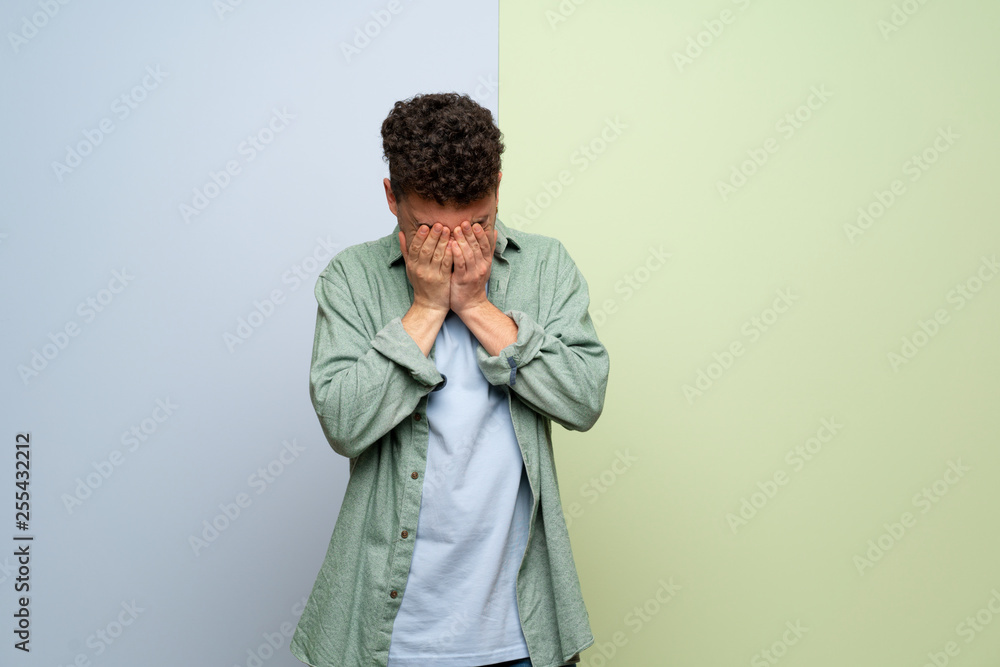 Obraz premium Young man over blue and green background with tired and sick expression