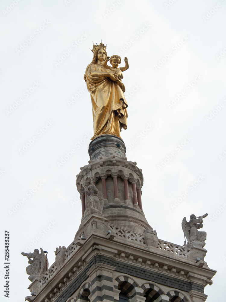 Fototapeta premium Belfry, bell tower and statue of the Virgin with child at Notre-Dame de la Garde (literally: Our Lady of the Guard) is a Catholic basilica in Marseille, France.