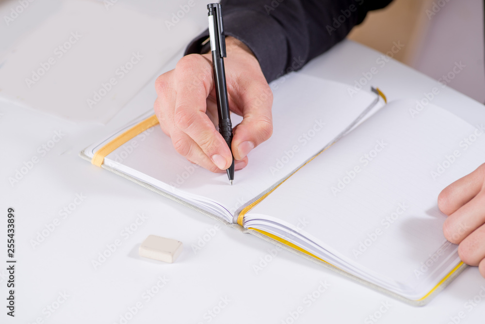 person makes notes and drawings in a notebook with a pen person makes notes and drawings in a notebook with a pen