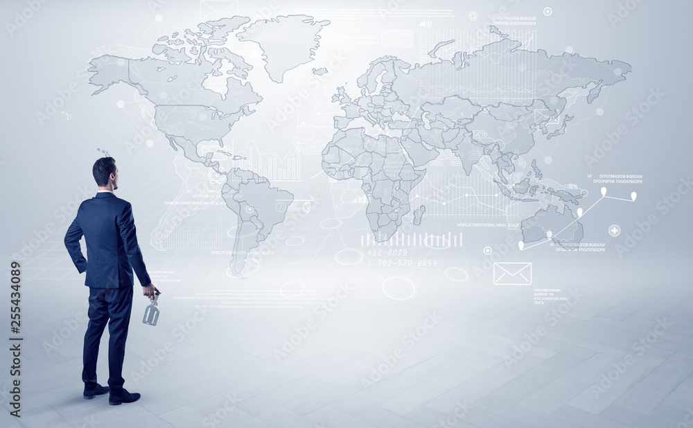 Businessman standing with his back and looking at a worldwide map with objects in his hand
Businessman standing with his back and looking at a worldwide map with objects in his hand
