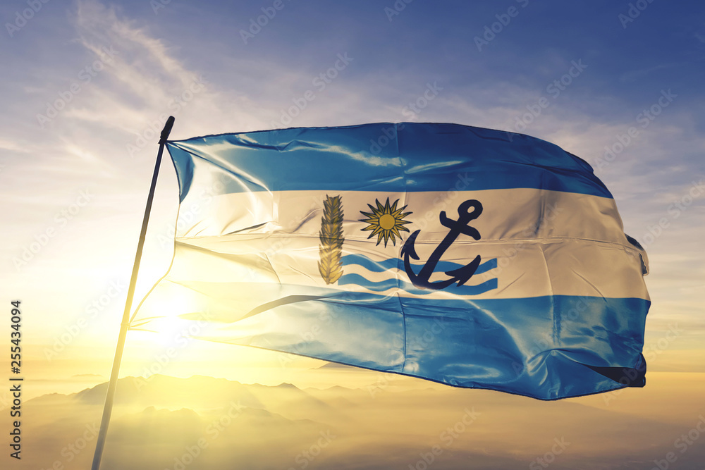 Rio Negro department of Uruguay flag waving on the top sunrise mist fog