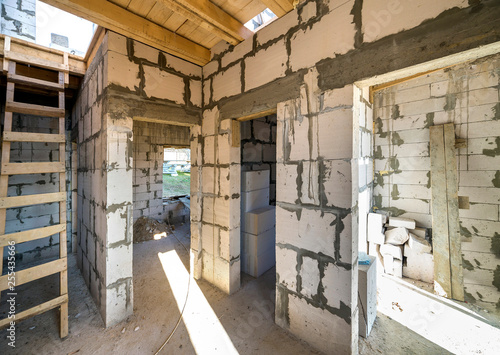 House room interior under construction and renovation. Energy saving walls of hollow foam insulation blocks, wooden ceiling beams and roof frame.