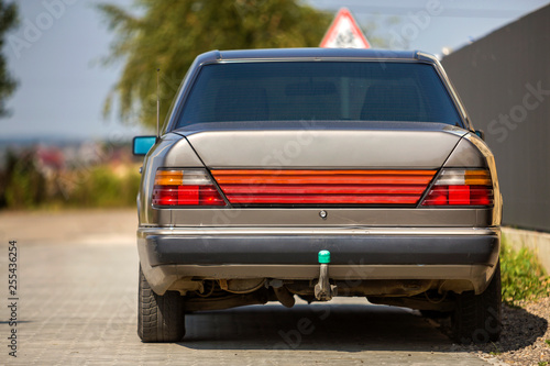 Εκτύπωση καμβά Back view of silver car parked on paved street in quiet area on sunny bright background