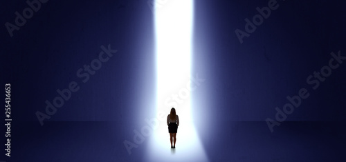 Woman standing and seeing the light at the end of a big wall   © ra2 studio