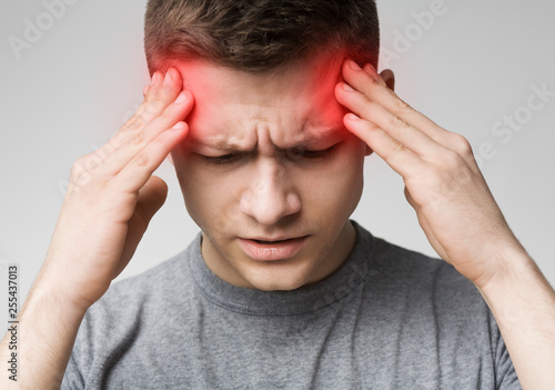 Man suffering from headache, touching his temples