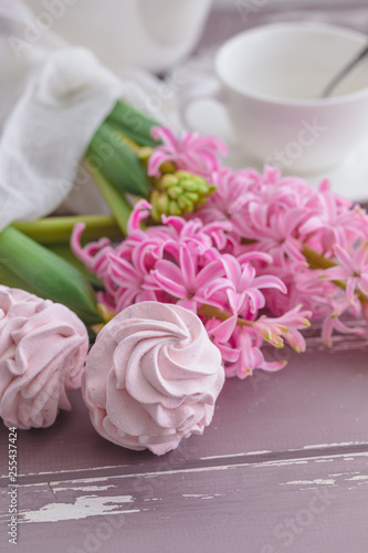 Traditional Russian homemade merengue marshmallow or zephyr on a plate with pink hyacinth on wooden background