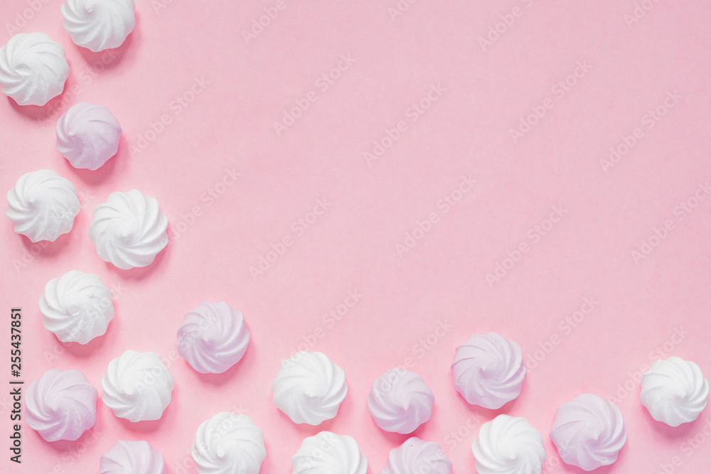 Top view of white and pink twisted meringues on pink background. French dessert prepared from whipped with sugar and baked egg whites. Greeting card with copy space Top view of white and pink twisted meringues on pink background. French dessert prepared from whipped with sugar and baked egg whites. Greeting card with copy space