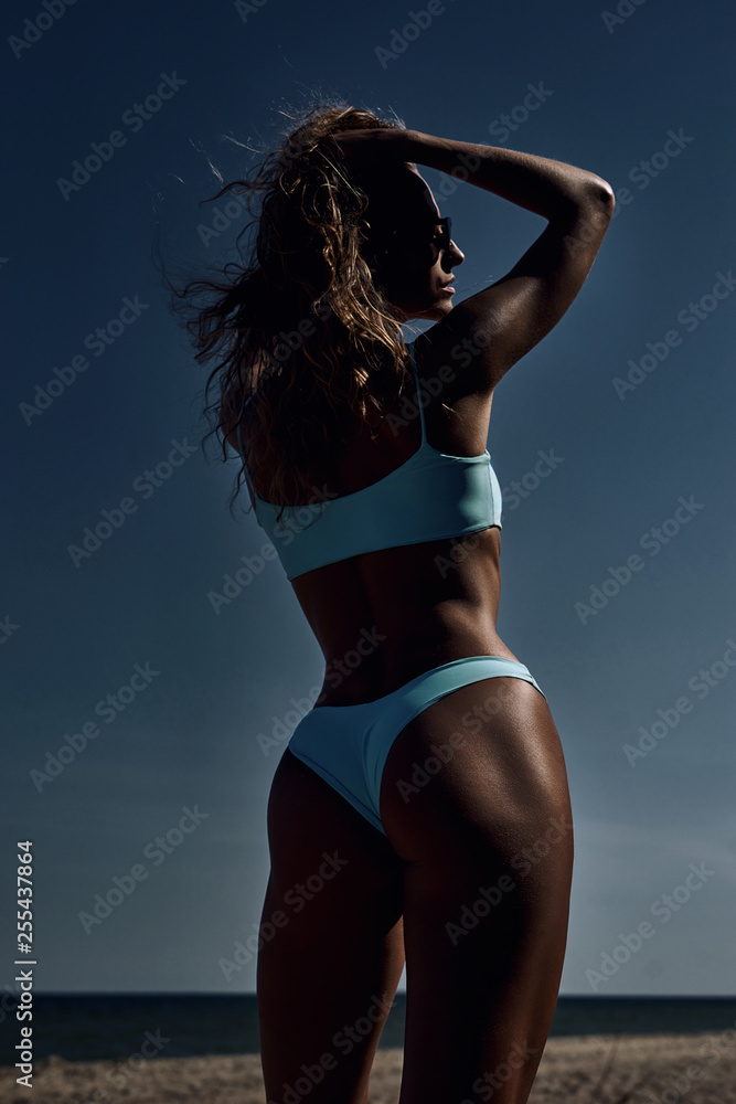 Fototapeta premium girl against the sky in a sports blue swimsuit