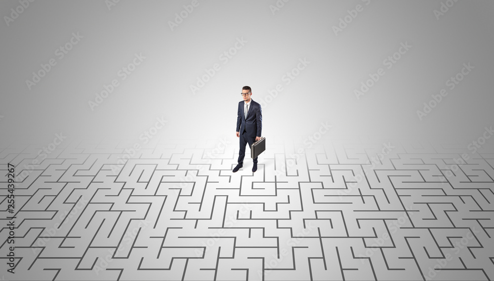 Elegant businessman looking for a solution in a middle of a maze
Elegant businessman looking for a solution in a middle of a maze
