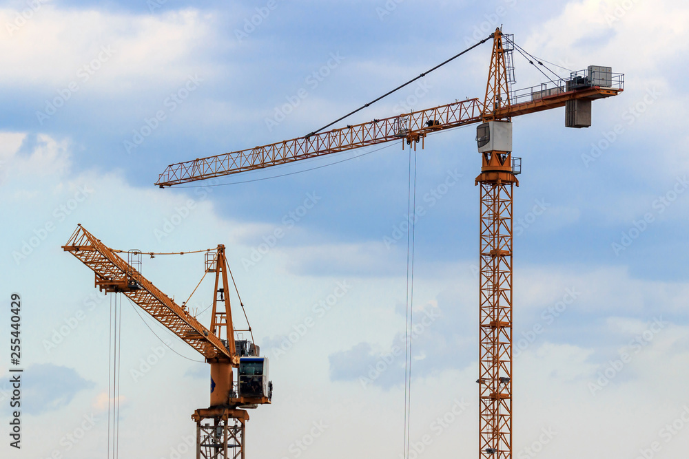 High-rise construction cranes on a blue sky background High-rise construction cranes on a blue sky background