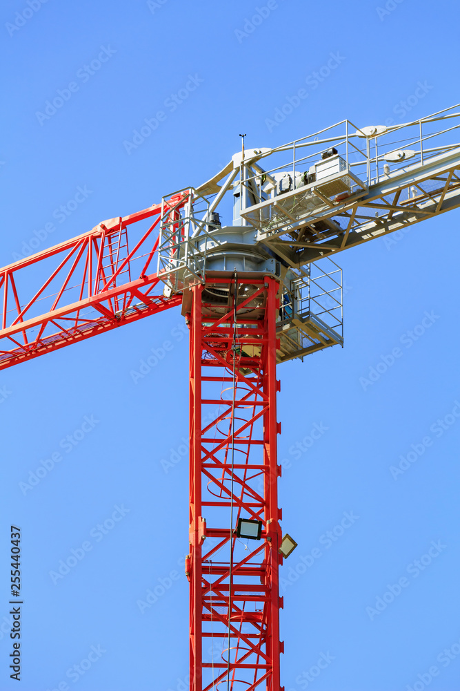 Fragment of modern high-rise cranes closeup on a blue sky background