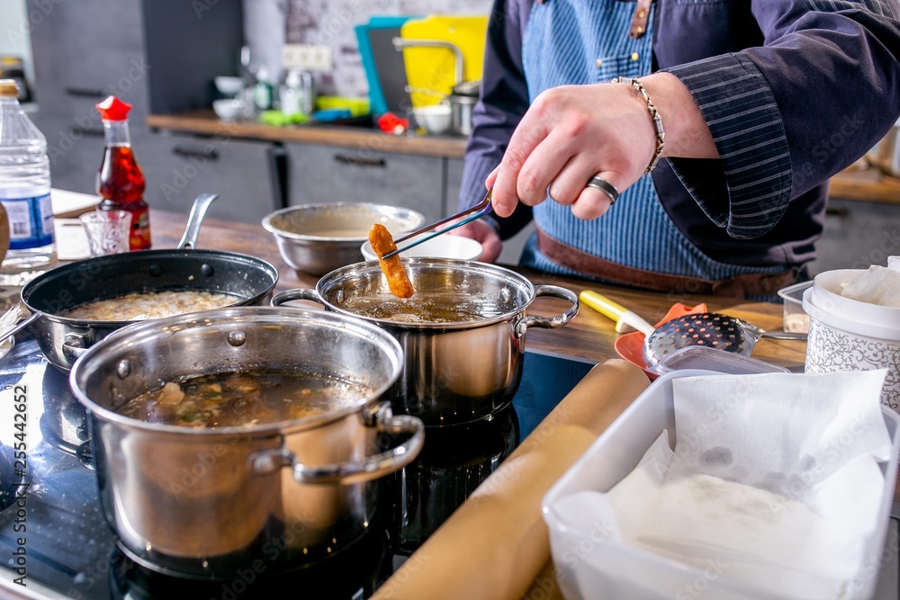 Chef pulls out fried fish pieces in batter. Master class in the kitchen. The process of cooking. Step by step. Tutorial. Close-up Chef pulls out fried fish pieces in batter. Master class in the kitchen. The process of cooking. Step by step. Tutorial. Close-up