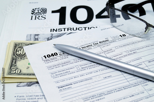 Obraz na płótnie Income tax form with instruction, glasses and pen. w salonie