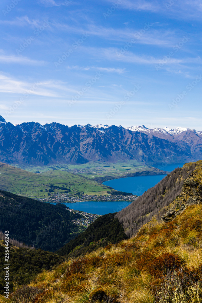 peaceful landscape during sunny day above the lake, valley and mountain range, mountain peaks partially covered with snow peaceful landscape during sunny day above the lake, valley and mountain range, mountain peaks partially covered with snow