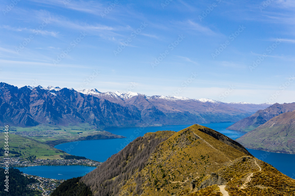 Fototapeta premium peaceful landscape during sunny day above the lake, valley and mountain range, footpath leading into the valley