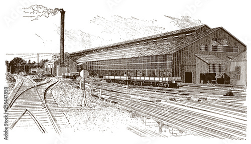 Exterior view of historical factory building with rails, wagons and smoking chimney, after engraving from 19th century