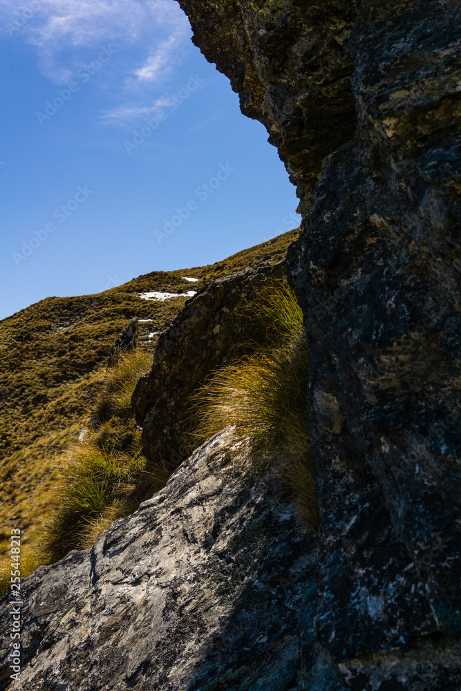 cave hidden in the mountains during sunny day