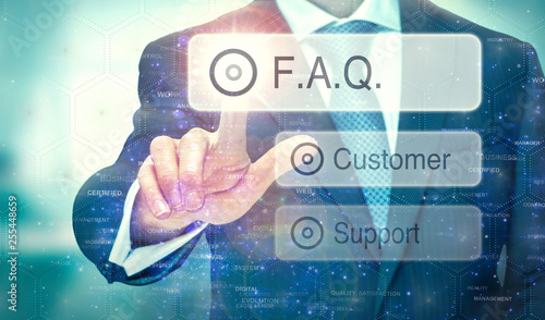 A business man selection a button on a futuristic display with a FAQ concept written on it.