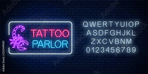 Tattoo parlor glowing neon signboard with scorpio emblem and alphabet. Tattoo salon sign in rectangle frame.