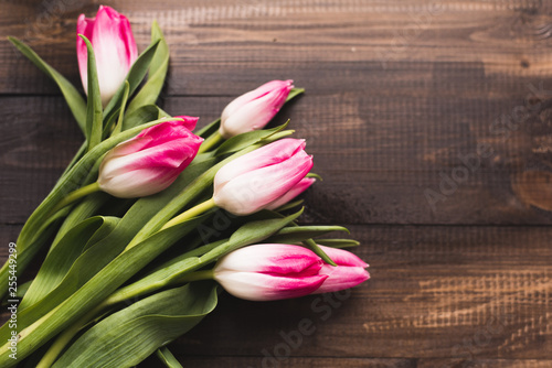 Fototapeta Naklejka Na Ścianę i Meble -  Fresh beautiful pink tulips on a wooden dark background with copy space