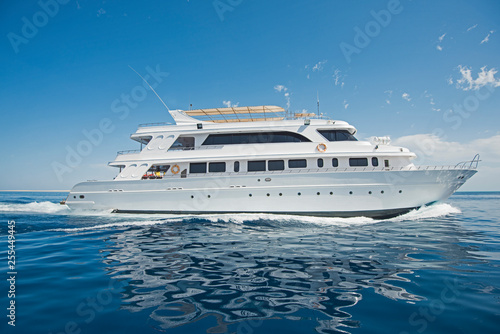 Luxury motor yacht sailing out on tropcial sea © Paul Vinten