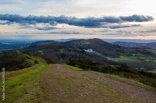 Path leading down jubilee hill with herefordshire beacon and southern part of the malvern hills in the background