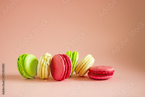 Macarons cakes of different colors on a pink background 