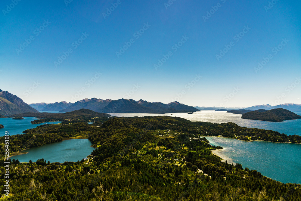 Scenic aerial nature colorful landscape photo of blue aquamarine lakes, rivers, Andes mountains, and green tree forest in Patagonia, Argentina