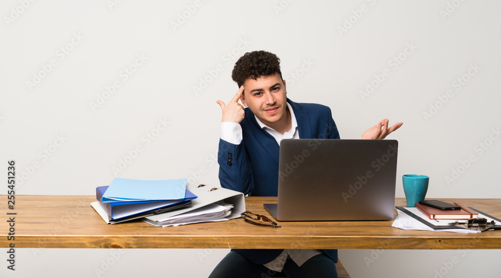 Business man in a office making the gesture of madness putting finger on the head Business man in a office making the gesture of madness putting finger on the head
