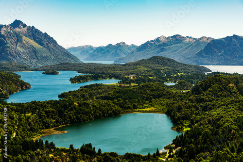 Scenic aerial nature colorful landscape photo of blue aquamarine lakes, rivers, Andes mountains, and green tree forest in Patagonia, Argentina