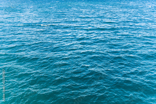 Blue turquoise transparent water surface of a sea ocean with waves