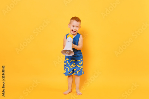 Kid boy 3-4 years old in blue beach summer clothes hold speak in megaphone isolated on bright yellow orange background children studio portrait. People childhood lifestyle concept Mock up copy space.