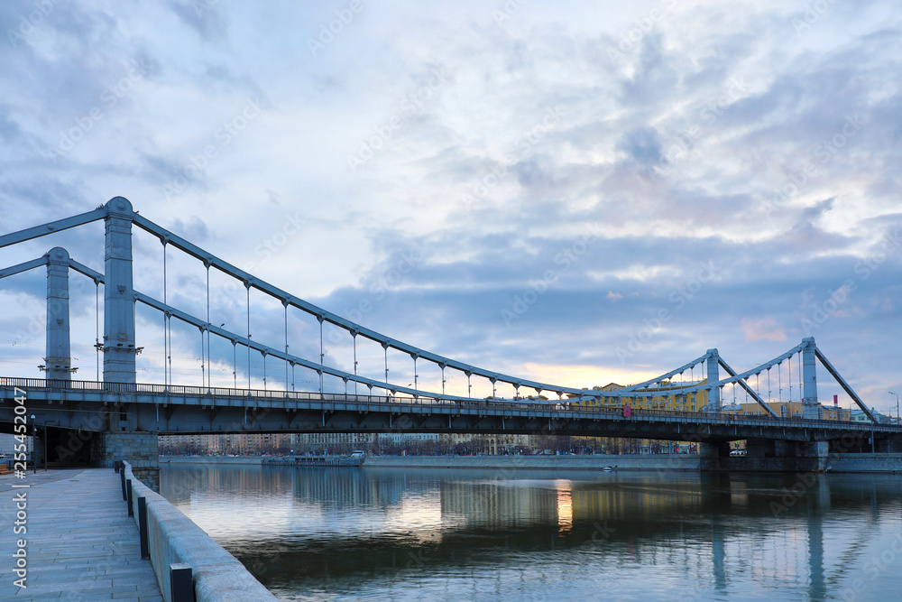 Obraz premium Krymsky Bridge or Crimean Bridge across the Moskva river in Moscow in the rays of setting sun in the evening blue hour 