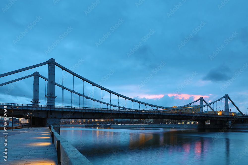 Obraz premium Krymsky Bridge or Crimean Bridge across the Moskva river in Moscow in the rays of setting sun in the evening blue hour 