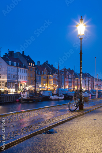 Photography Isolated street light with bicycle in blue twilight and view to embankment Nyhav