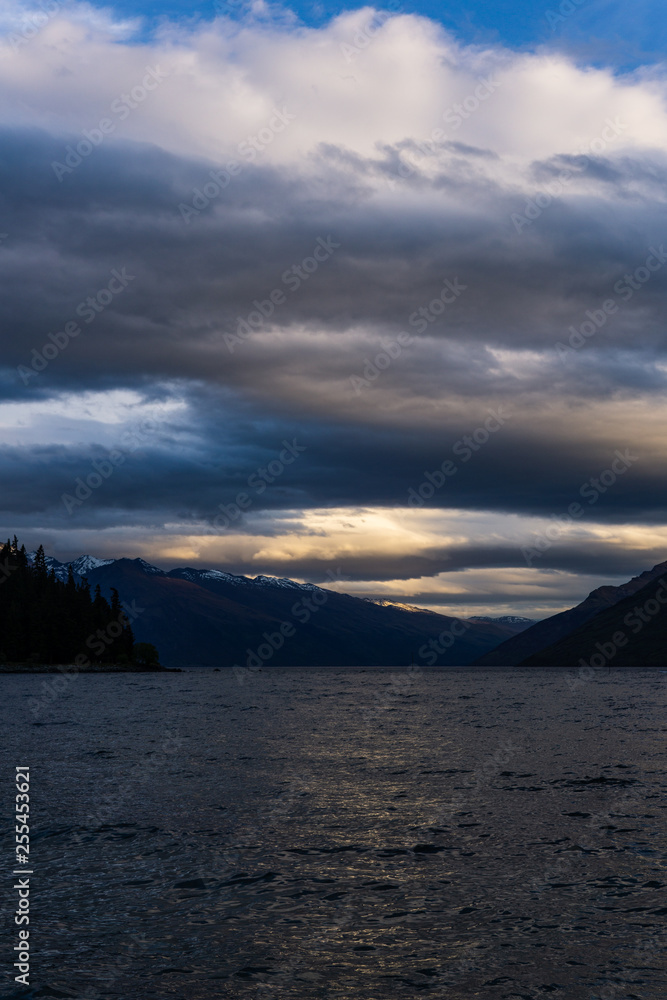 dramatic sky during dark sunset over mountain range, lake in the foreground dramatic sky during dark sunset over mountain range, lake in the foreground