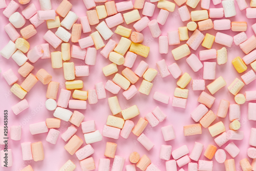 Top view on multi-colored marshmallows on a monochrome pink background Top view on multi-colored marshmallows on a monochrome pink background