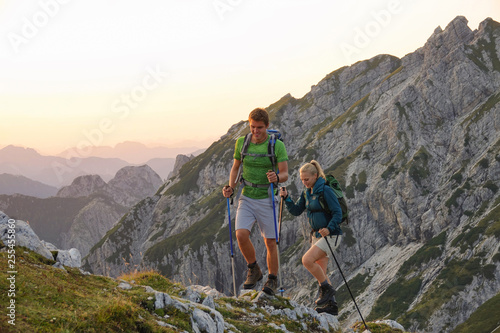 Carefree male and female tourists exploring the mountains in the early morning.