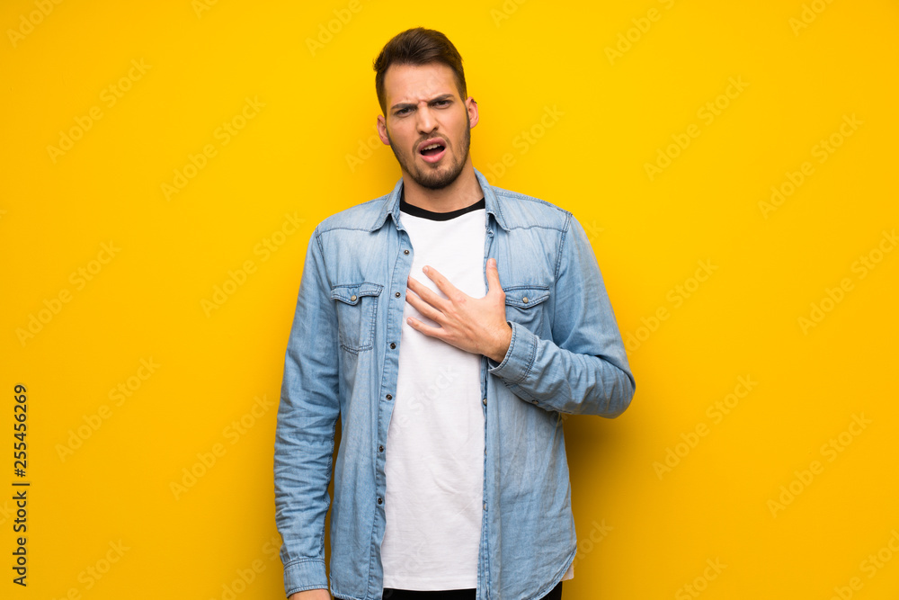 Handsome man over yellow wall surprised and shocked while looking right Handsome man over yellow wall surprised and shocked while looking right